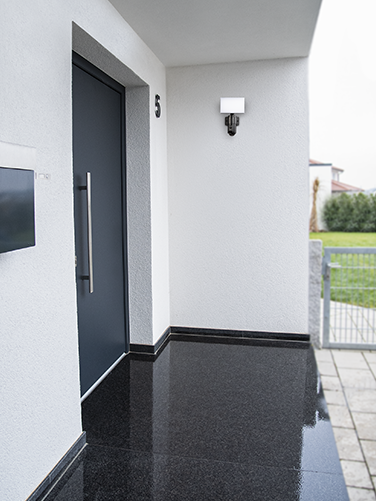 The Hama surveillance camera with light and motion detector is mounted on an outside wall next to the front door