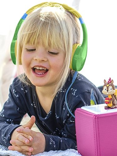 Girl listens to a radio play with the Hama "Kids Guard" children's headphones