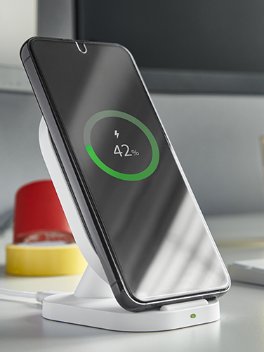 Smartphone is charged on wireless charger.