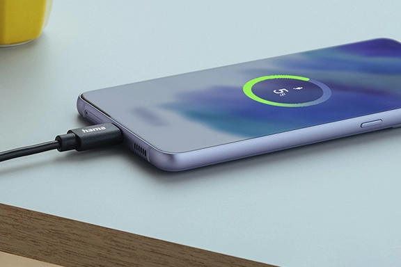 Android smartphone lies on a table and is charged via the Hama "Fabric" charging cable