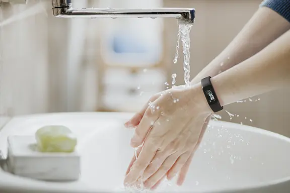Fitness Tracker bleibt beim Händewaschen am Handgelenk.