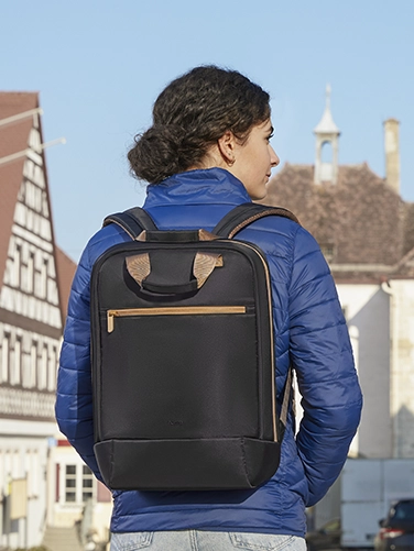 A young woman walks through the city with the Hama "Ultra Lightweight" laptop rucksack on her back