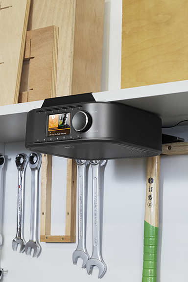 Digital radio mounted on a shelf in a workshop.
